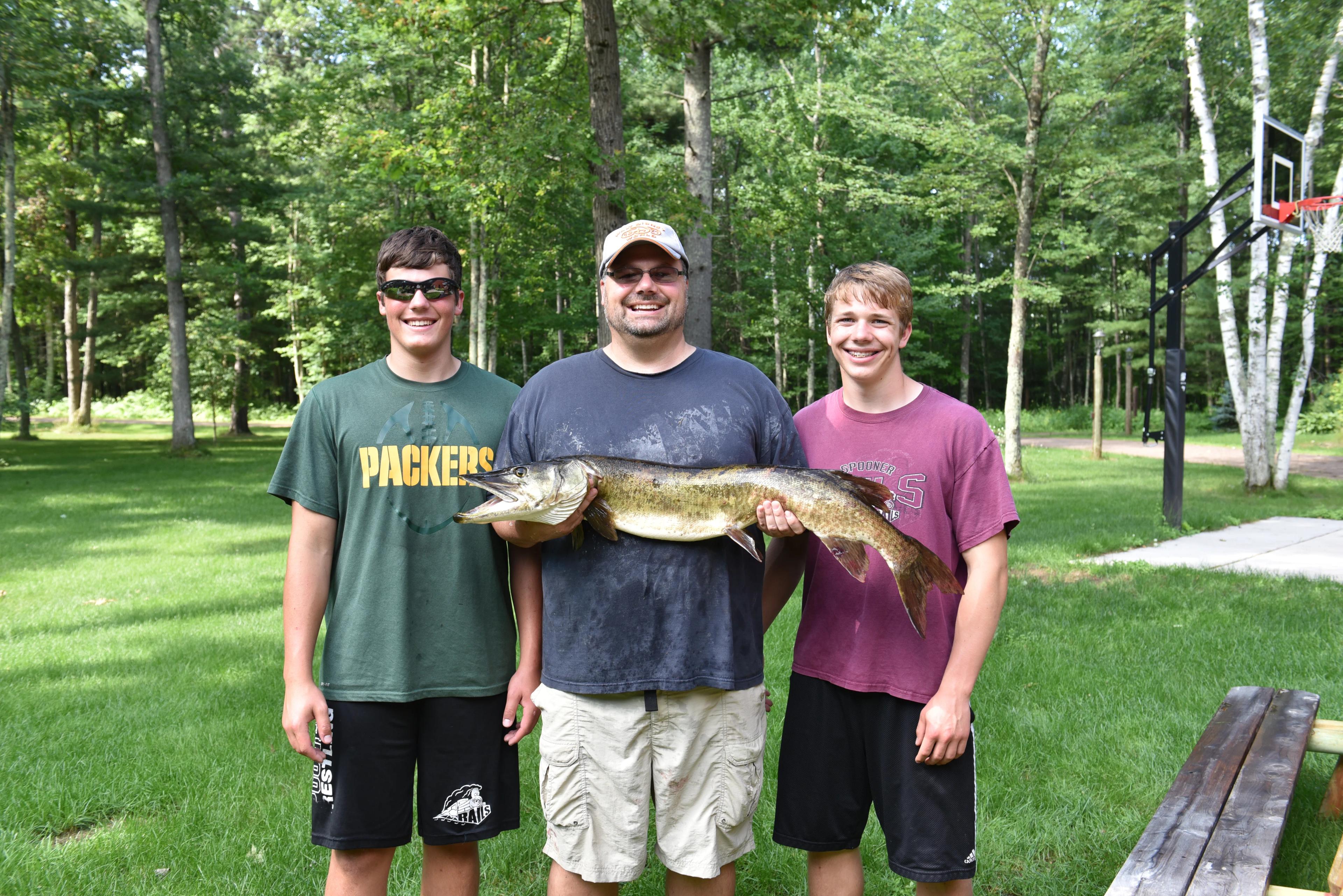 Dr. Carroll with his sons holding a musky caught near Spooner, WI